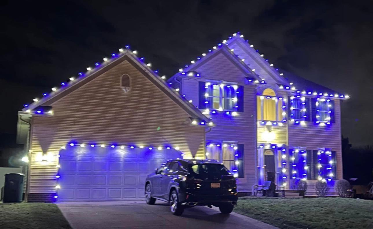 Blue and white roofline and window lighting on a two-story home