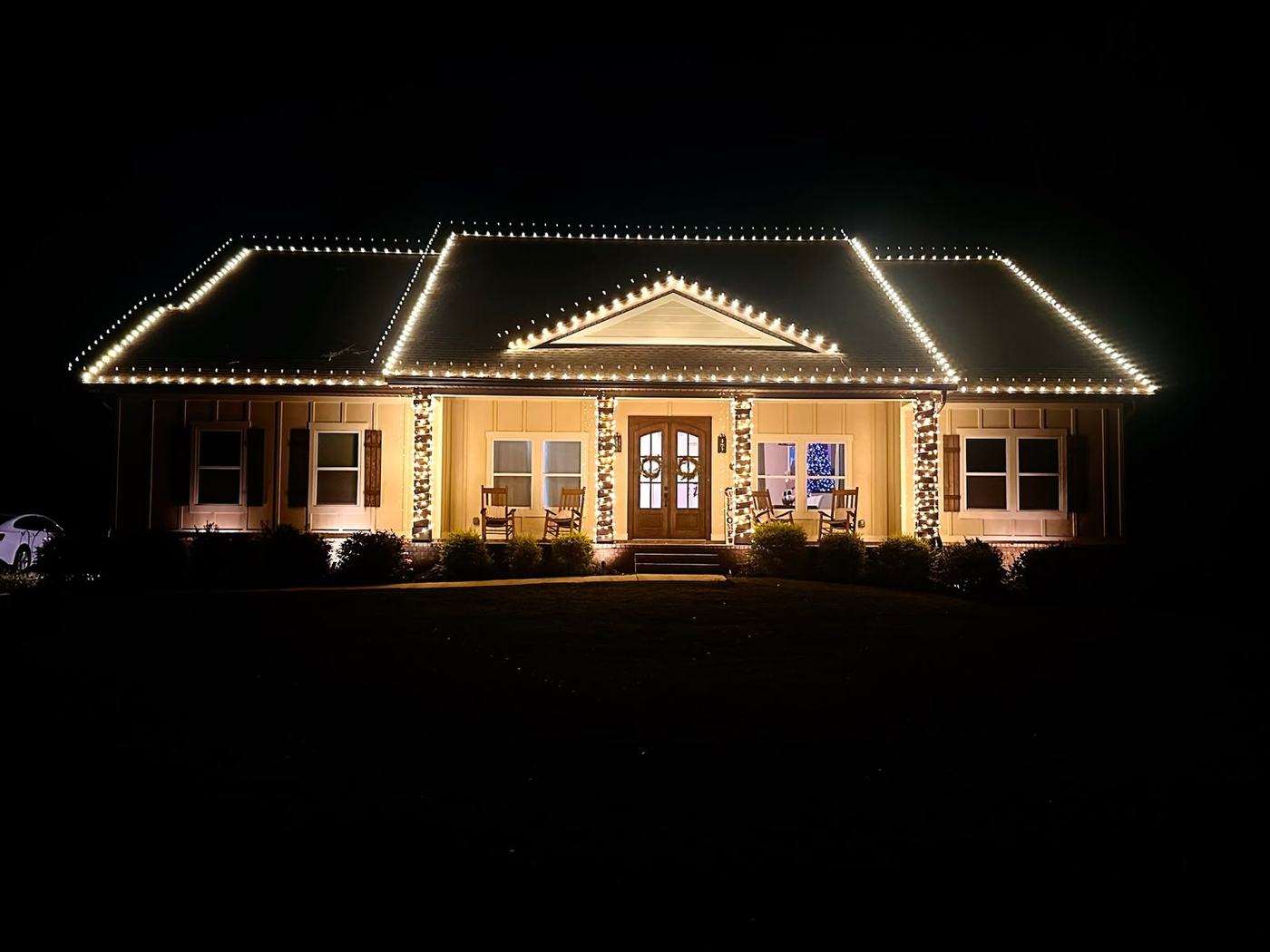 Warm white roofline and porch column lighting on a single-story Tampa home