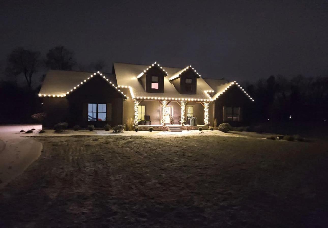 Warm white roofline and porch lighting on a craftsman home